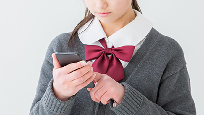 スマホを操作する女子学生